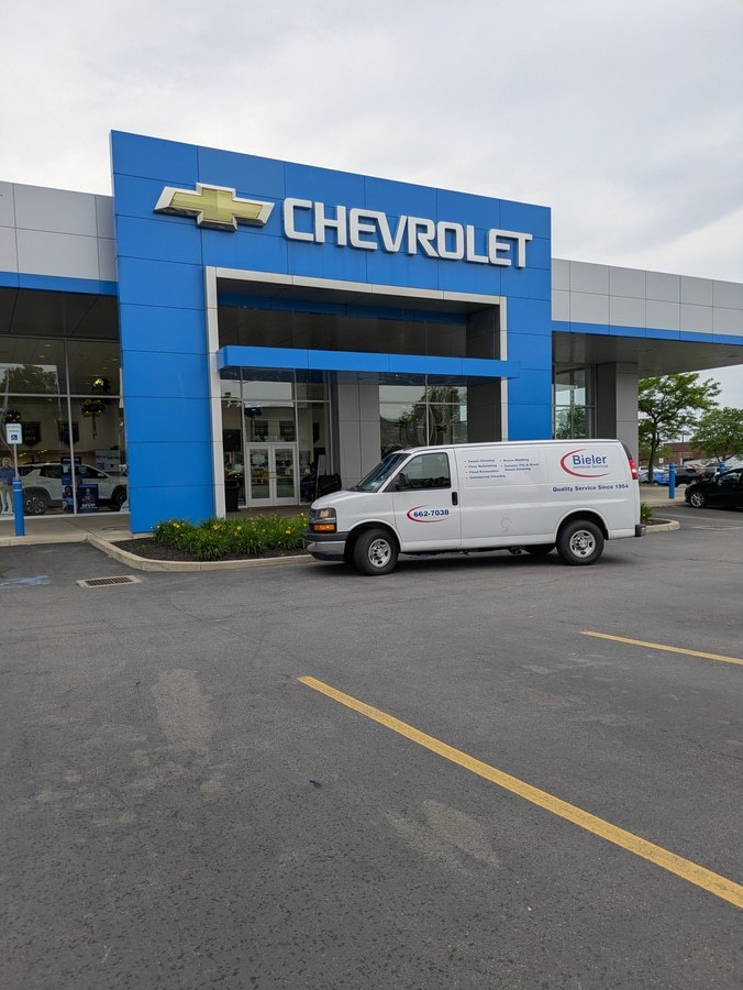 work van in front of chevrolet dealer