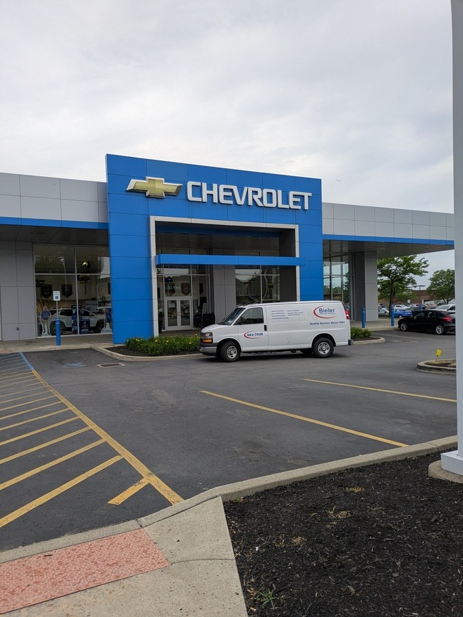 work van in front of chevrolet dealer