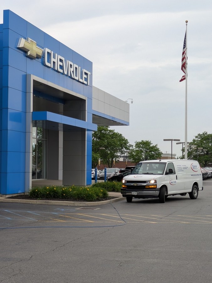 work van in front of chevrolet dealer
